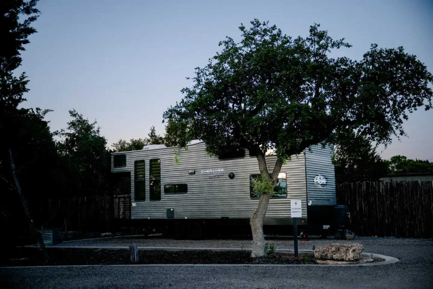 Blancobreeze glamping RV under a live oak at dusk at Wayside Wimberley